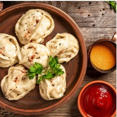 Momos & tea: Steaming plate of Himalayan momos and a cup of Darjeeling tea served together